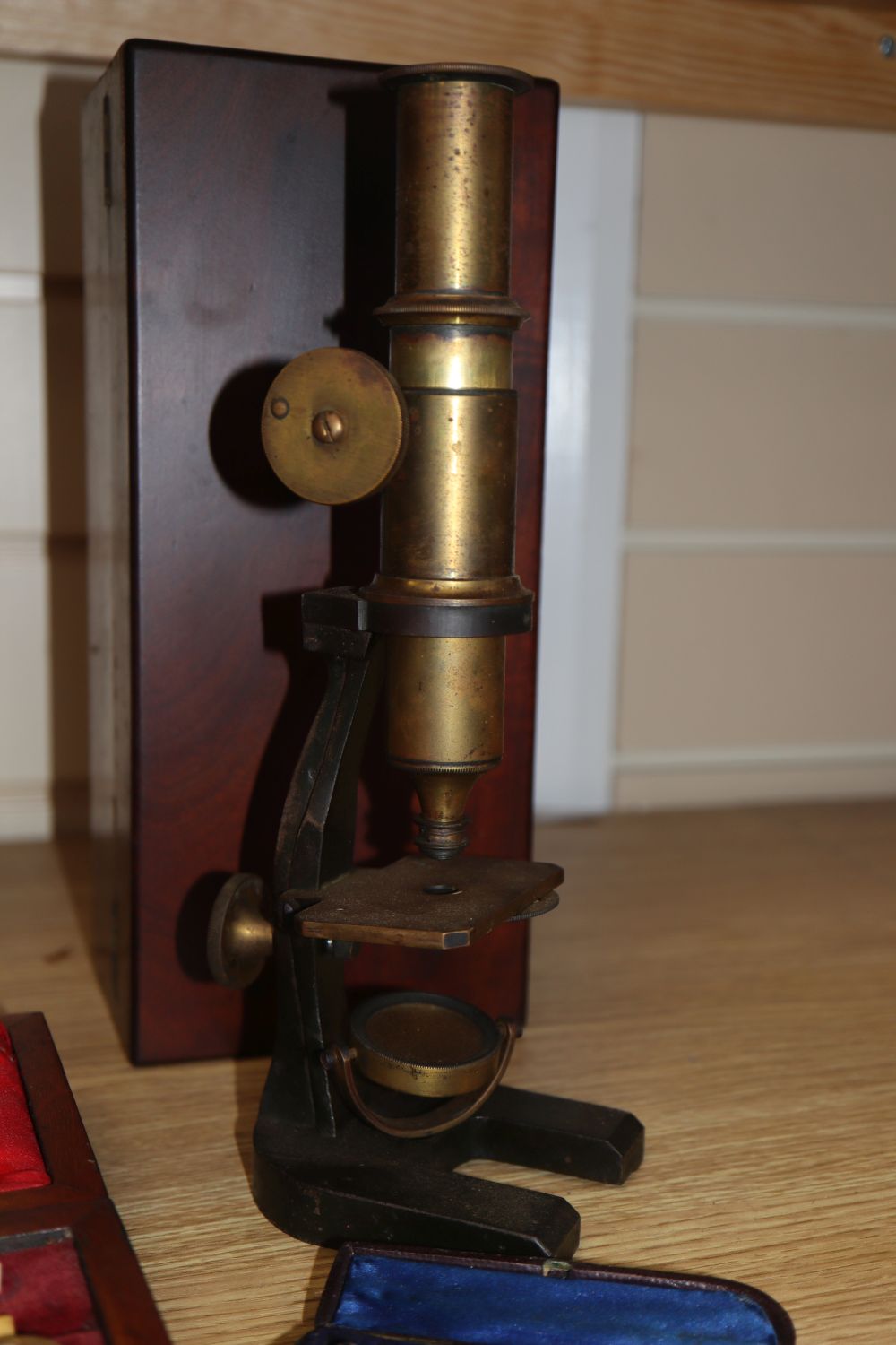 A cased microscope, a cased Sikes hydrometer and two thermometers